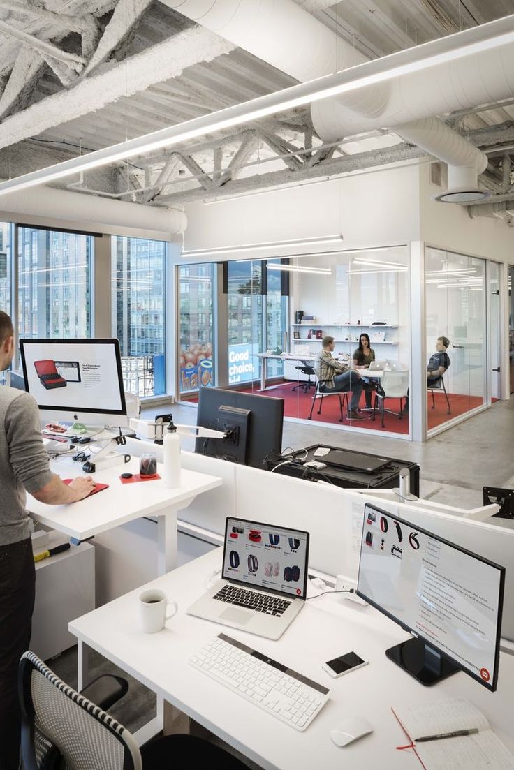 an office with multiple computers and people working