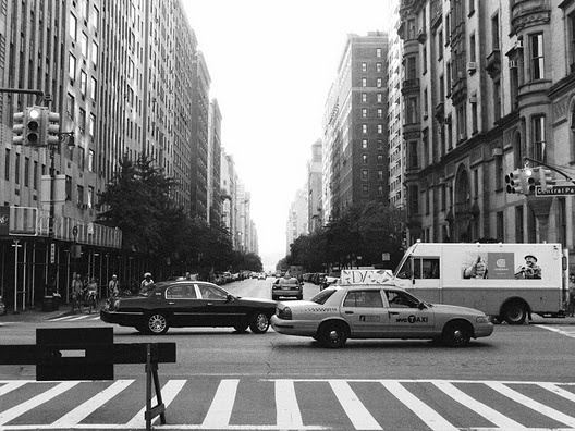 a black and white photo of traffic on a city street