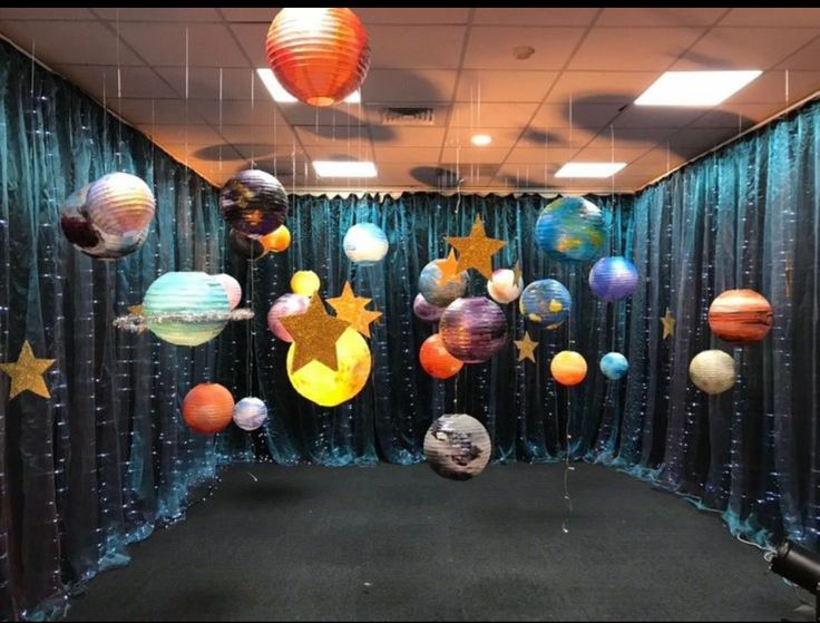 an office cubicle decorated with balloons, stars and other decorations for the space theme