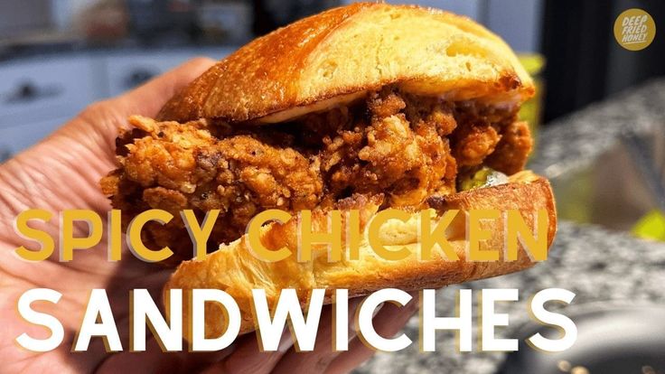 a person holding a sandwich in their hand with the words spicy chicken sandwiches on it