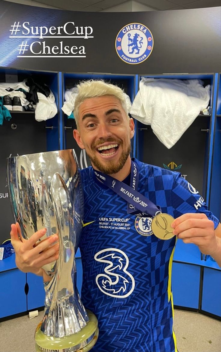 a man holding a soccer trophy and wearing a blue shirt