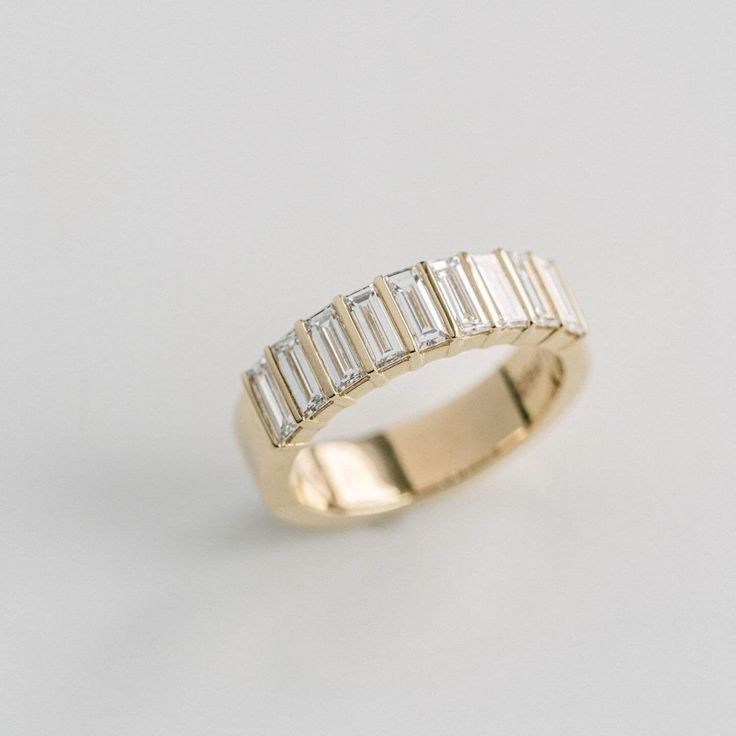 a yellow gold ring with baguets on it