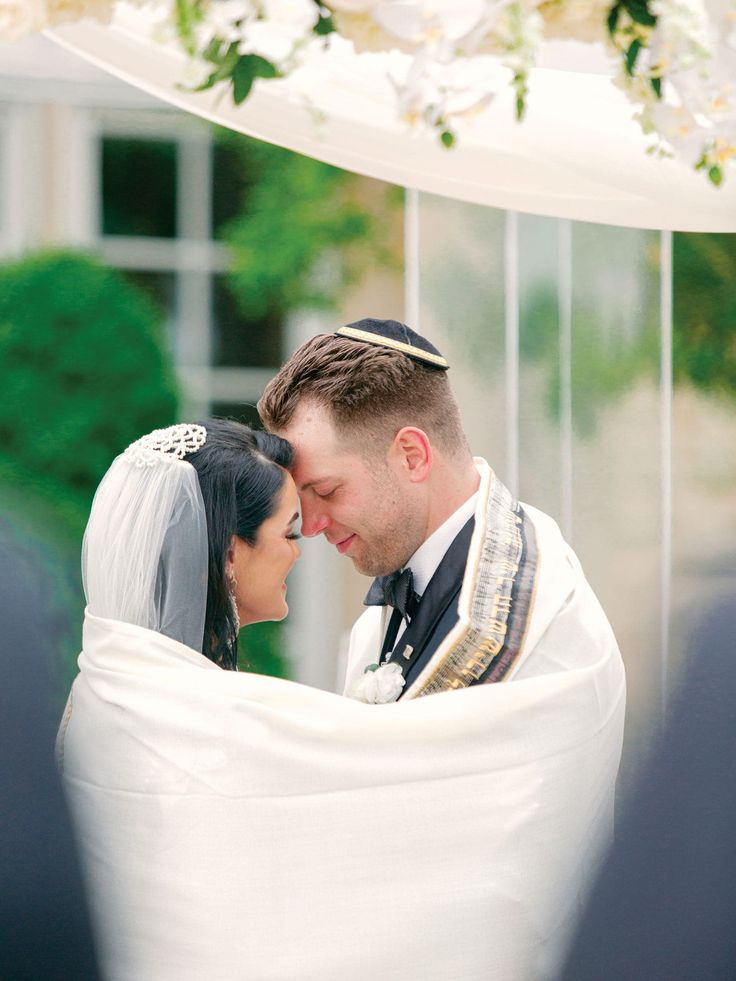 a bride and groom standing under a wedding chute