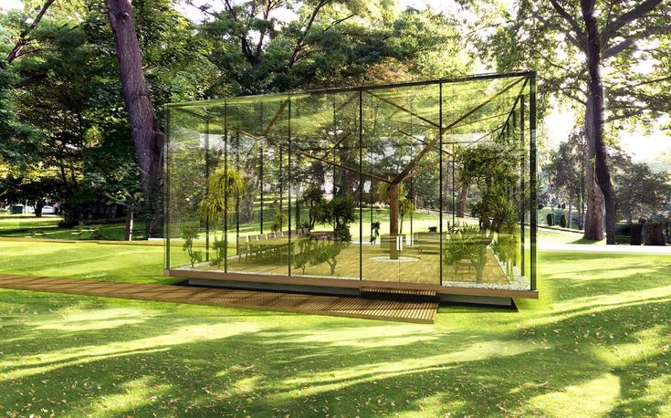 a glass box in the middle of a grassy area with trees and grass around it