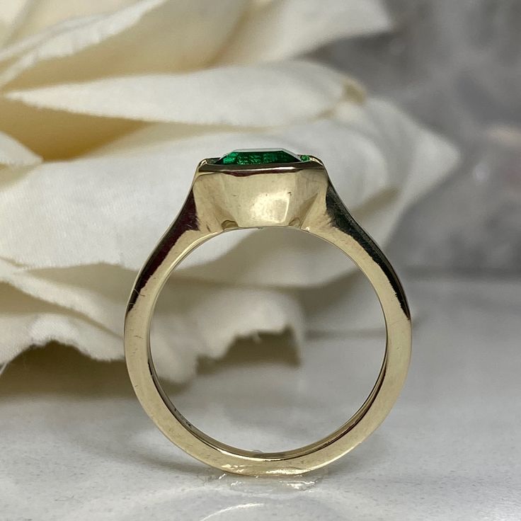 a close up of a ring with a flower in the background