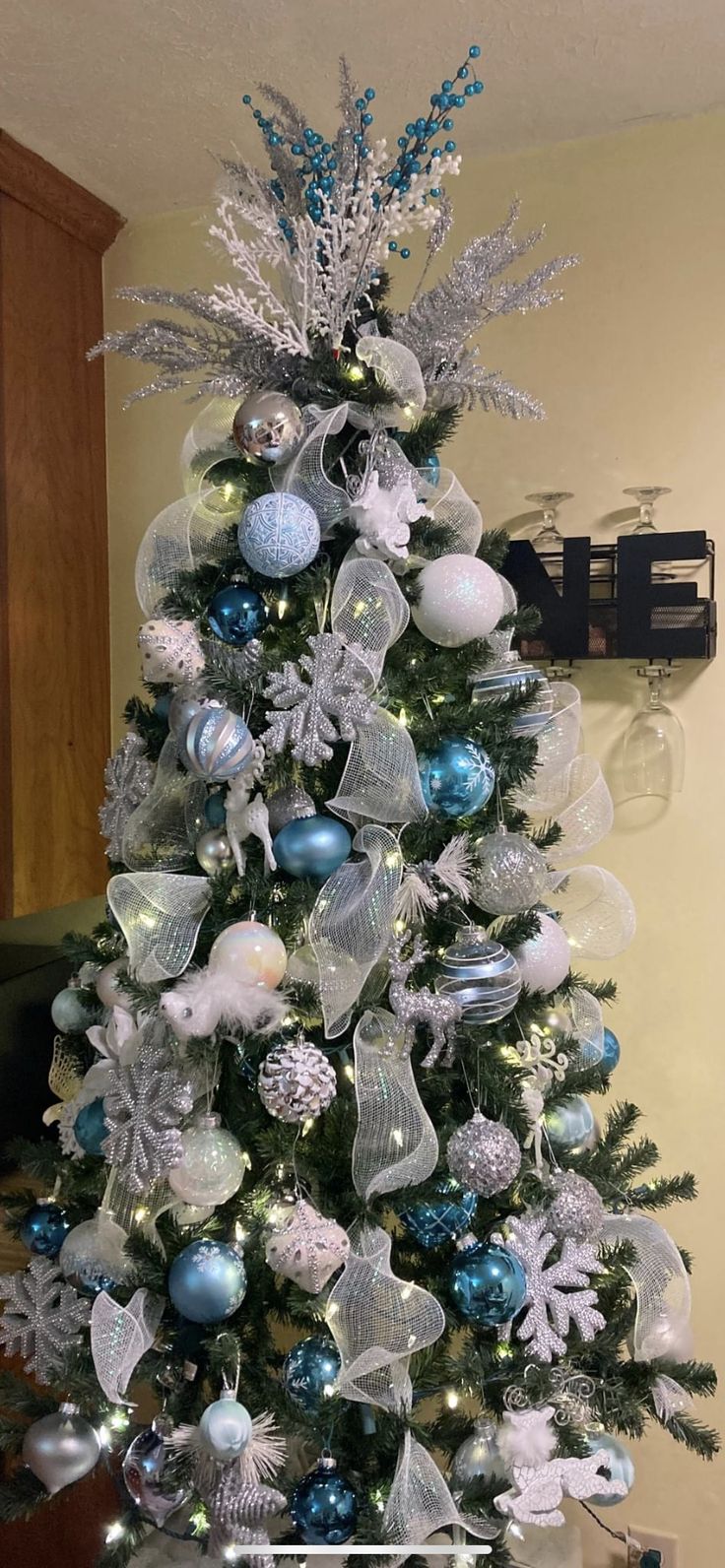 a white christmas tree with blue and silver ornaments