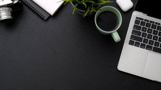 an open laptop computer sitting on top of a desk next to a cup of coffee