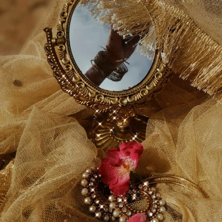 a close up of a mirror with a flower on it