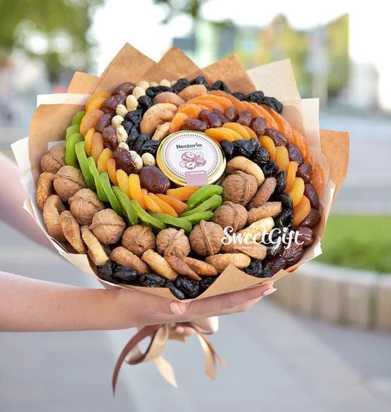 a person holding a bunch of different types of nuts in their hands, with the words sweet gift on it