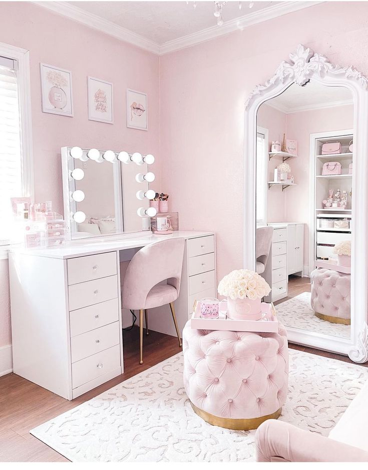 a bedroom with pink walls and white furniture in the room, including a dressing table