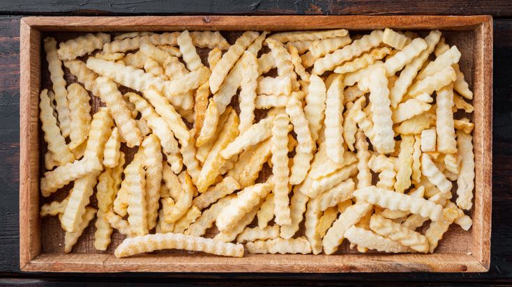 french fries in a wooden box on a table