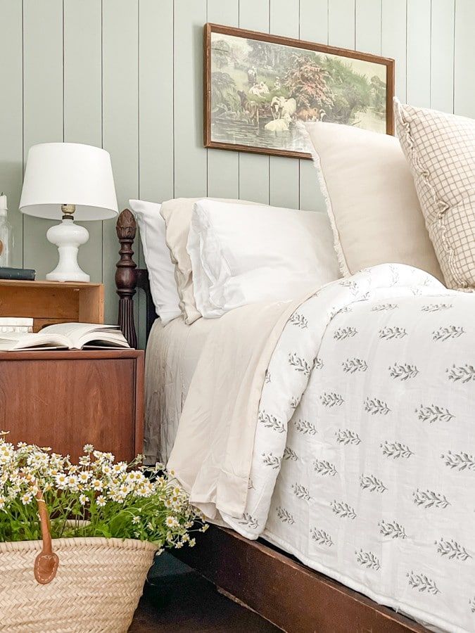 a bed sitting next to a basket filled with flowers