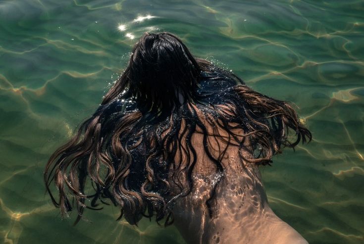 a person in the water with long hair