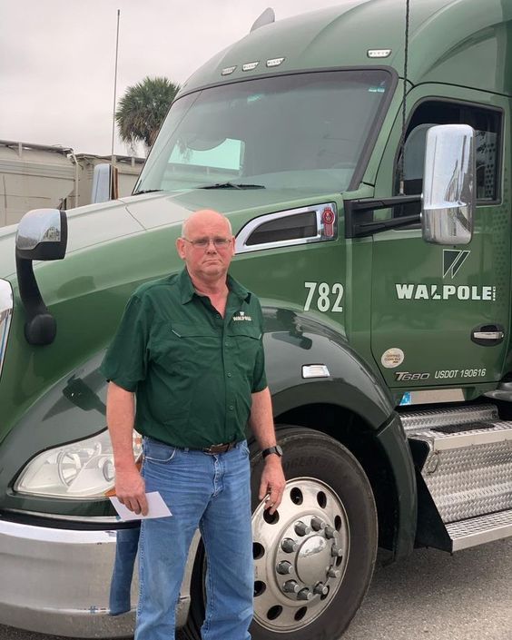 a man standing in front of a semi truck