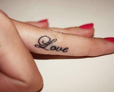 a woman's hand with a small tattoo that says love on it and the word love written in cursive font