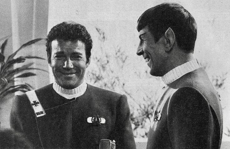 two men standing next to each other smiling