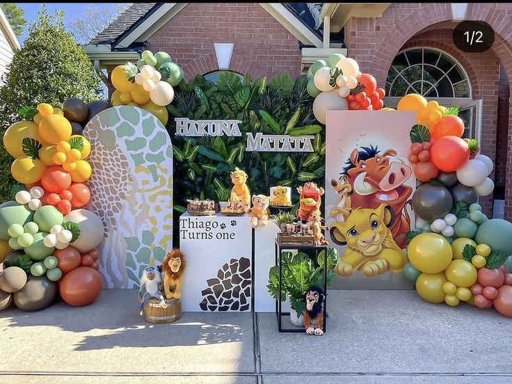 the lion king birthday party is set up in front of a house with balloons and decorations