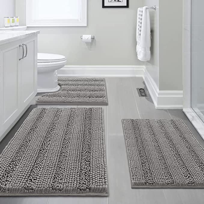 a bathroom with two rugs on the floor