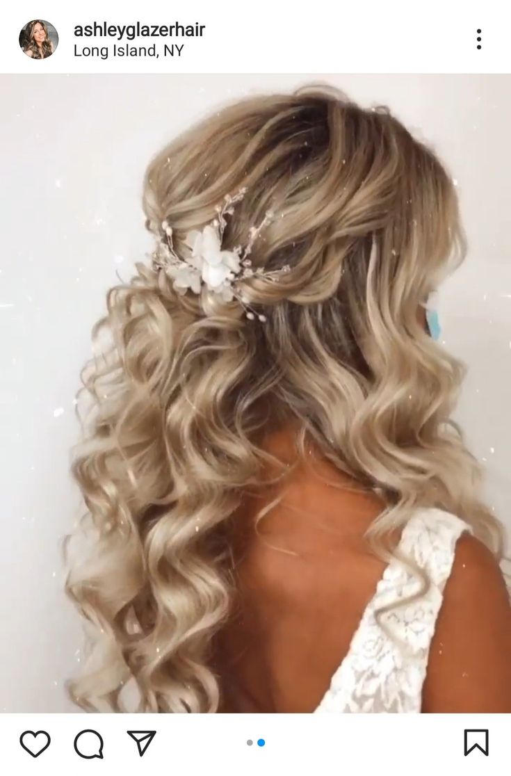 the back of a woman's head with wavy hair and flowers in her hair