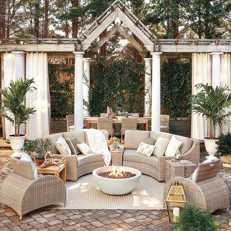 an outdoor living area with wicker furniture and potted plants