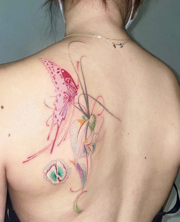 the back of a woman's shoulder with a butterfly and flower tattoo on it