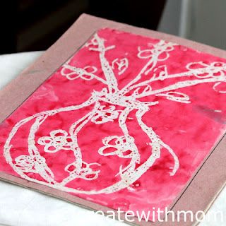 a red piece of art with white designs on it