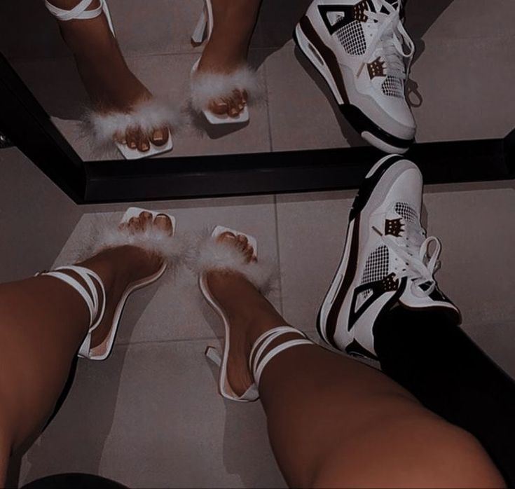 two pairs of feet with white and black shoes