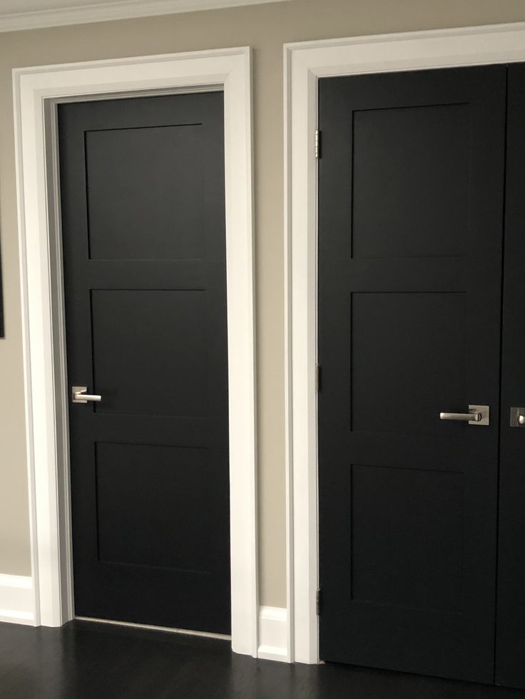 two black doors in a room with white trim