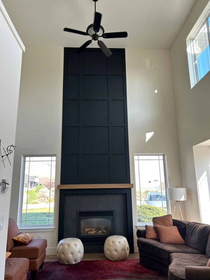 a living room with couches and a ceiling fan