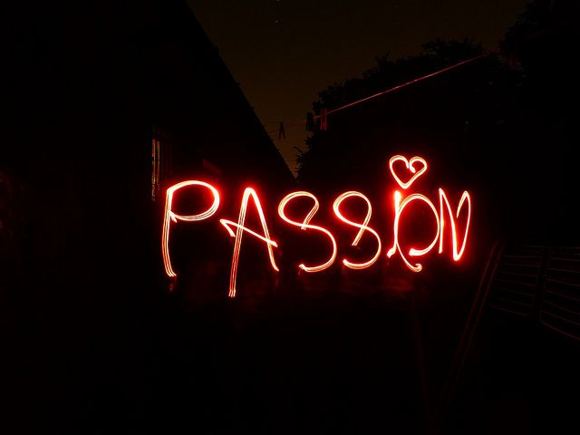 a neon sign with the word passion written on it in red light, against a dark background