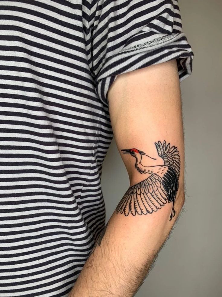 a man with a bird tattoo on his arm