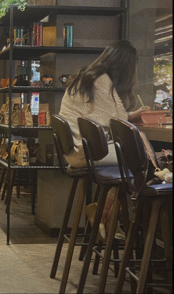 a woman sitting at a table in a library