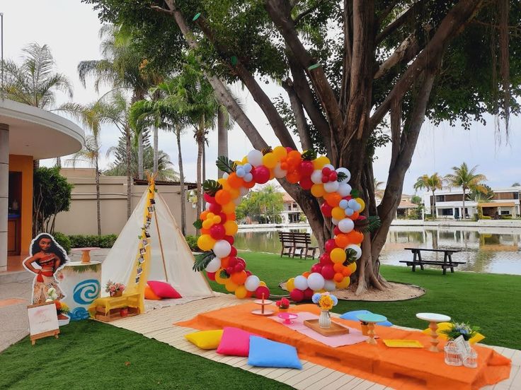 an outdoor birthday party setup with balloons and streamers in the shape of a heart