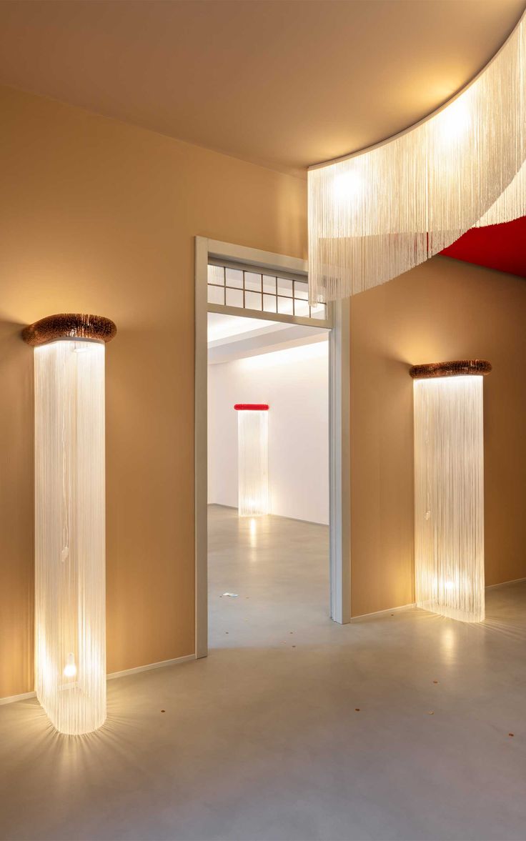 an empty room with some lights on the wall and two tall pillars in front of it