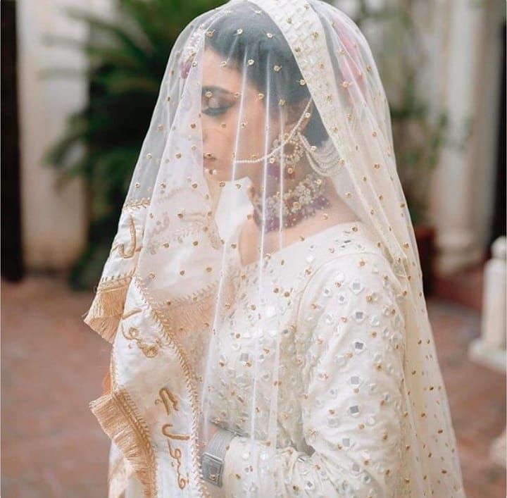 a woman wearing a white bridal gown and veil