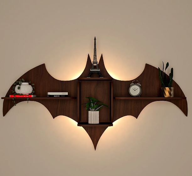 a wooden shelf that has various items on it and is shaped like a batman's wing