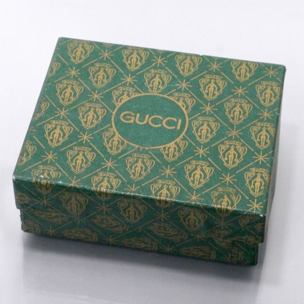 an open gucci box sitting on top of a table