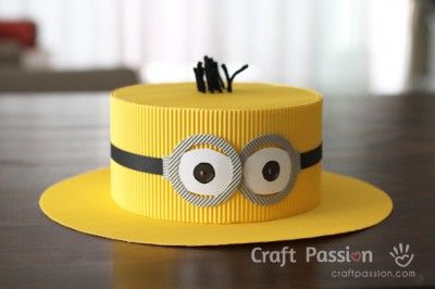 a yellow hat with googly eyes on it sitting on top of a wooden table