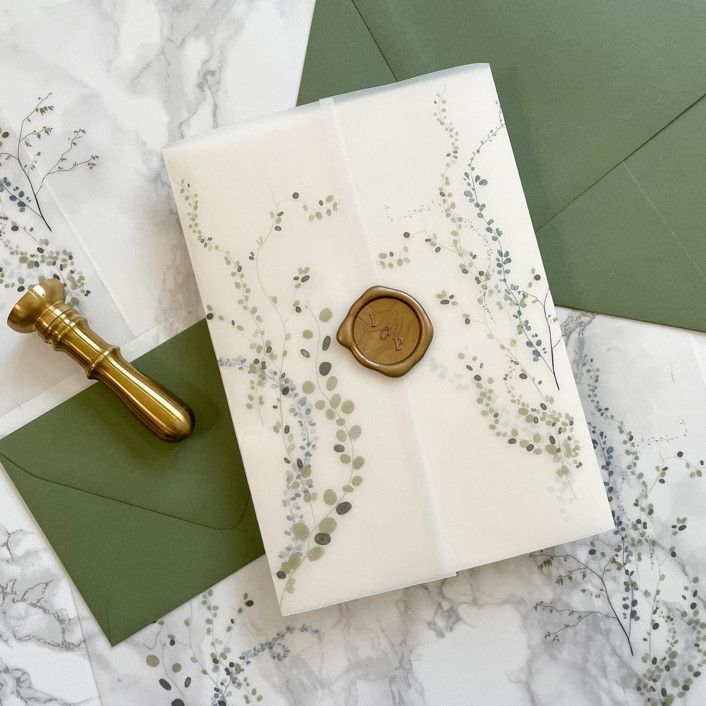 an envelope with a wax stamp on it next to some green envelopes and money