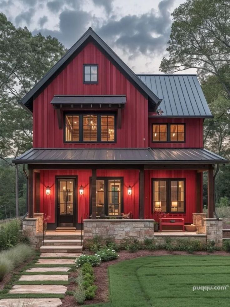 a red house with black roof and stairs leading up to the front door, surrounded by grass