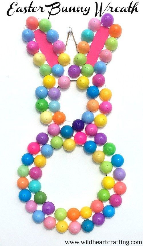 an easter bunny necklace made out of colorful beads and plastic eggs on a white background