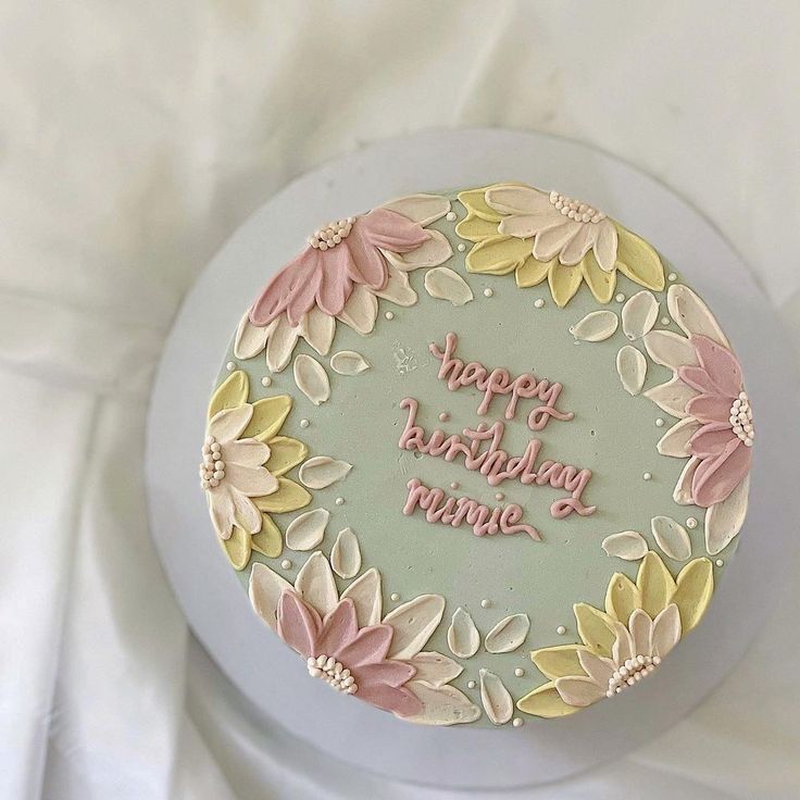 a birthday cake decorated with flowers on a plate