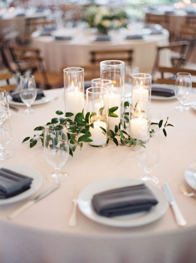 the table is set with candles and place settings for guests to sit down at it