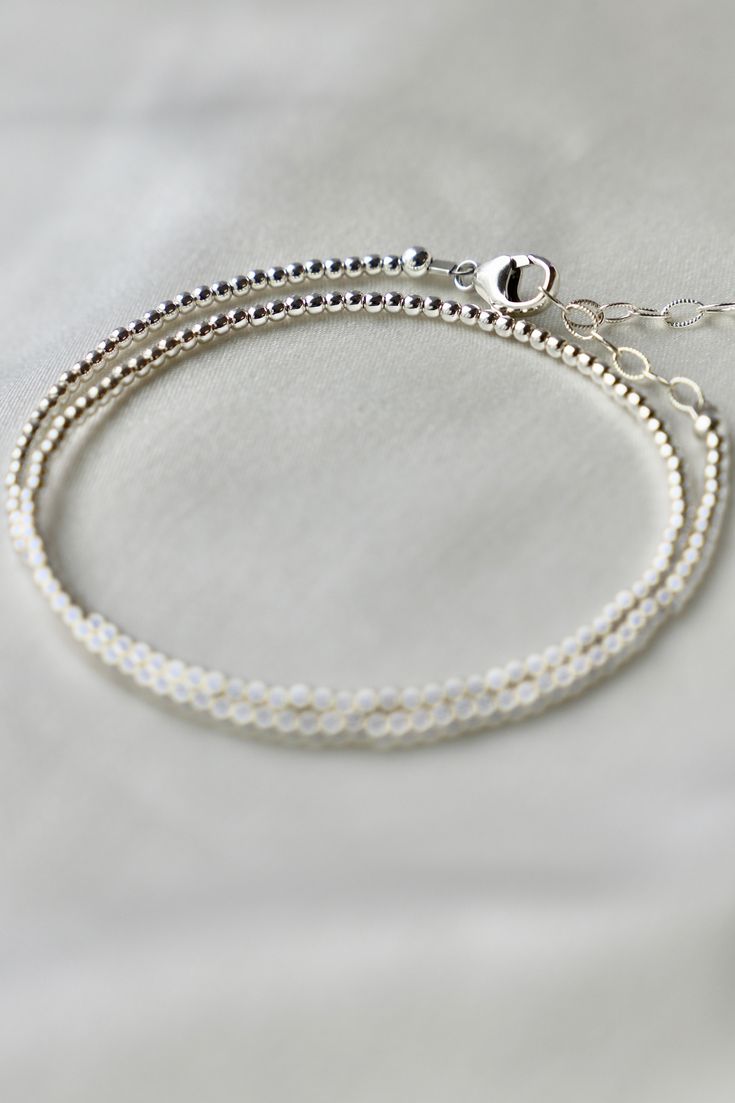 Our double wrap bracelet is one of our number one best selling bracelets. The petite double wrap beaded bracelet features a sterling silver 2mm bead that can be worn as a bracelet or a single layer choker necklace.Materials: Sterling silver beads Length: Measures an adjustable 14-15 inch length with a 2 inch extender SKU: B1182 Materials+Care Silver Double Strand Bracelet, Minimalist Silver Bracelets With Tiny Beads, Double Strand Sterling Silver Bracelet For Gift, Sterling Silver Double Strand Bracelet Gift, Dainty Silver Bracelets With Tiny Beads, Sterling Silver Bracelets With Ball Chain, Sterling Silver Bracelets With Ball Chain And Round Beads, Tiny Beads Multi-strand Bracelet, Minimalist Beaded Bracelets With Ball Chain