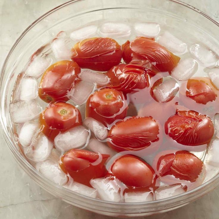 tomatoes and ice in a bowl on a table