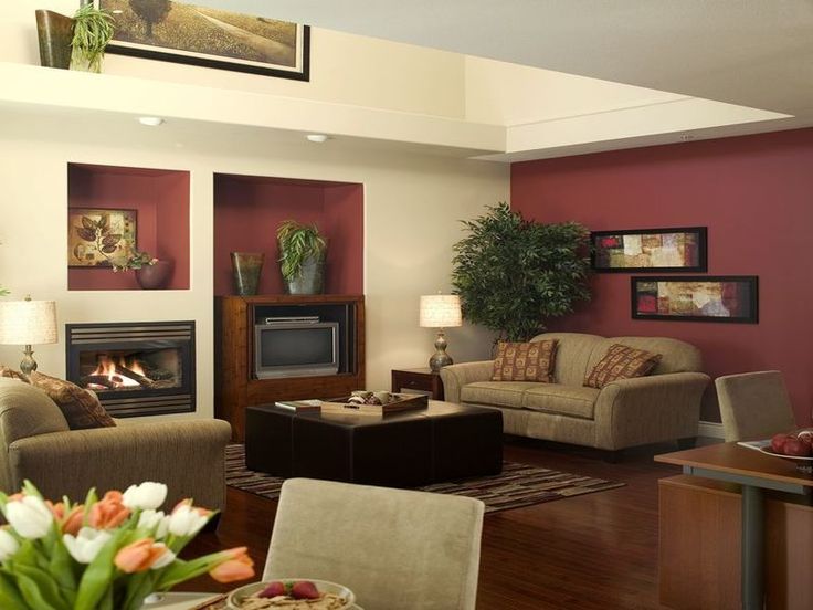 a living room with two couches and a fire place in the fireplace, surrounded by pictures on the wall