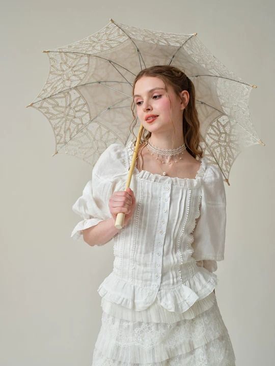 Linennaive's affinity for romantic, vintage-inspired silhouettes is evident in this blouse. Made from soft linen and scattered with 4 different old French lace-trimmed, it has a vintage-inspired square neckline with romantic puffed sleeves and flared cuffs. It finished with a smocked rear panel that adds shape and comf Feminine Ruffled Peasant Top With Square Neck, Feminine Summer Lace Top With Lace Cuffs, Square Neck Ruffle Blouse For Daywear, Feminine Blouse With Lace Trim And Square Neck, Feminine Square Neck Blouse With Lace Trim, Summer Puff Sleeve Lace Top, Puff Sleeve Blouse For Garden Party, Summer Lace Blouse With Puff Sleeves, Summer Lace Top With Puff Sleeves