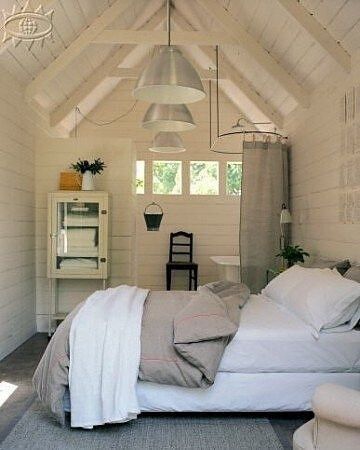 a bedroom with white walls and vaulted ceiling