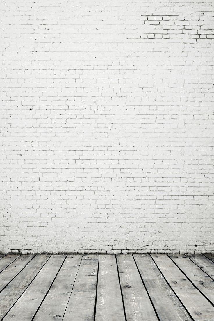 an empty room with white brick wall and wooden floor