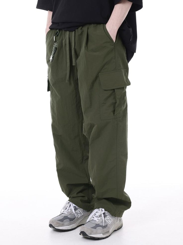 It is string cargo pants with the 100% nylon fabric. You can adjust the size with the waist string. You can wear it casually. - Wide fit - Waist banding- Pin tuck detail on the front thigh- Cargo pockets- Stopper on the hem Khaki Relaxed Fit Techwear Cargo Pants, Utility Khaki Cargo Pants With Elastic Waistband, Utility Cargo Pants With Elastic Waistband In Khaki, Urban Style Khaki Parachute Cargo Pants, Khaki Combat Style Parachute Pants, Combat Style Nylon Cargo Pants With Pockets, Casual Khaki Parachute Pants For Outdoor Activities, Military Style Cargo Parachute Pants For Outdoor Activities, Techwear Khaki Parachute Pants With Cargo Pockets